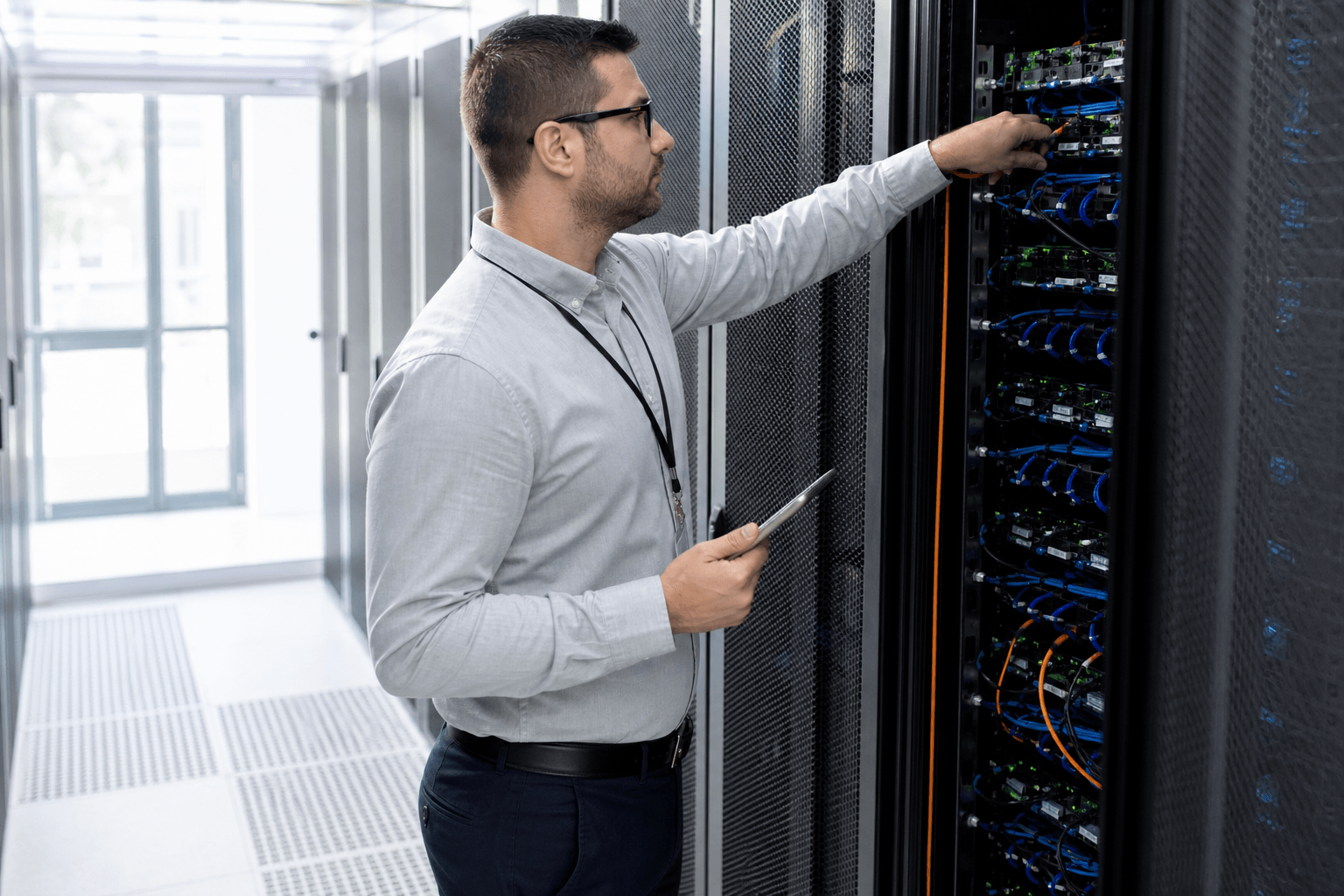 Technician working on a Hetzner-style server rack in a data centre